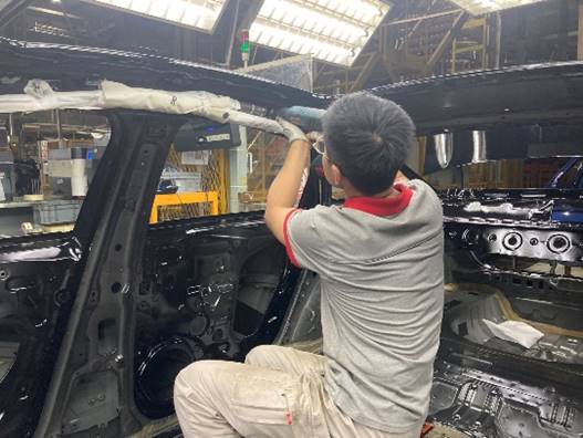 男孩站在汽车旁低可信度描述已自动生成